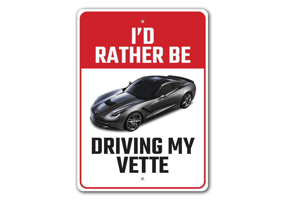 Metal sign featuring the phrase 'I'd Rather Be Driving My Corvette', showcasing a sleek design perfect for car enthusiasts.