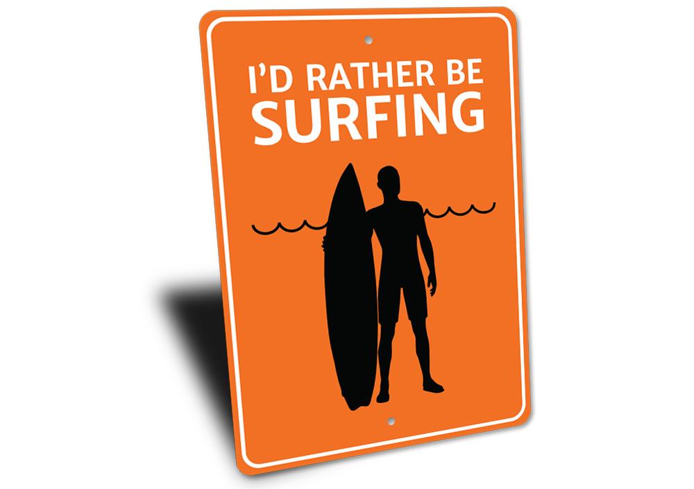 A decorative metal sign reading 'I'd Rather Be Surfing', featuring vibrant colors and a beach-themed design, perfect for coastal decor.