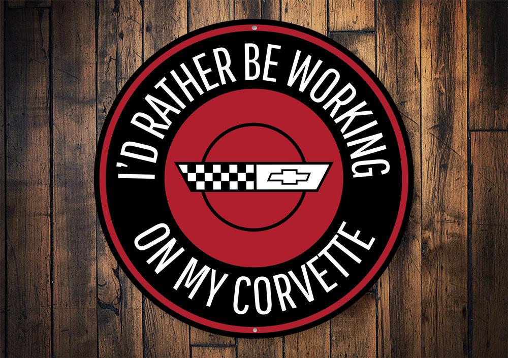 A decorative metal sign featuring the phrase 'I'd Rather be Working on my Corvette', showcasing vibrant colors and a sleek design, perfect for car enthusiasts.