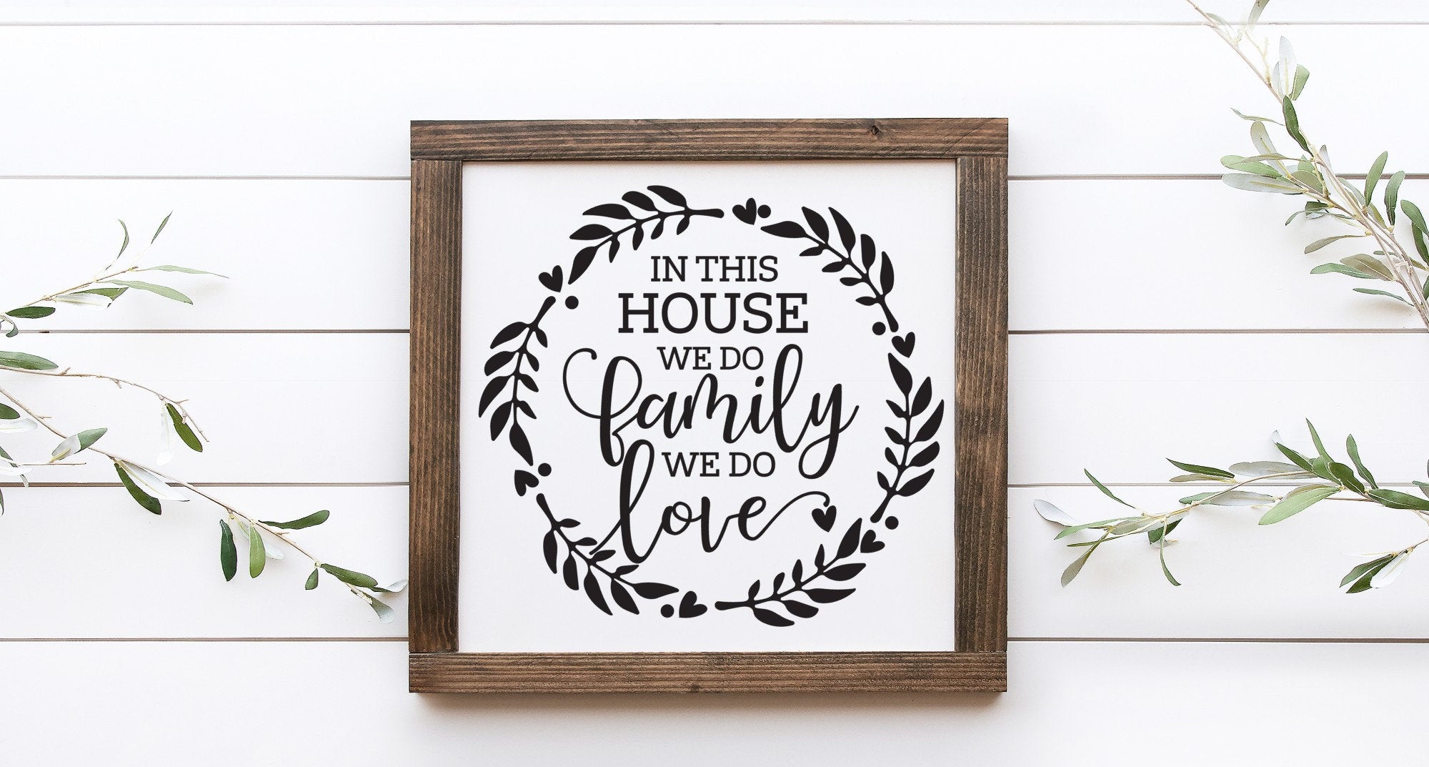 Handmade wood sign with the phrase 'In This House We Do Family We Do Love', featuring a matte white background and unique wood grain.