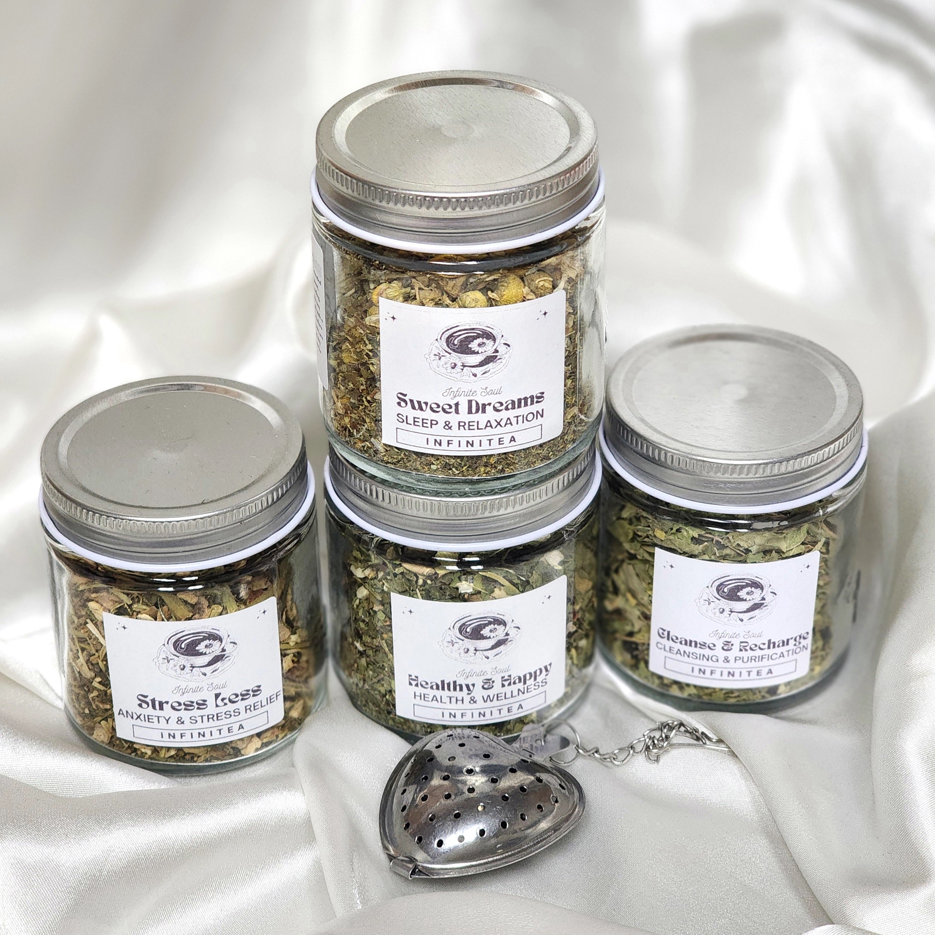 Infinitea Health & Wellness Bundle Pack featuring four herbal teas and a strawberry tea infuser, beautifully arranged.