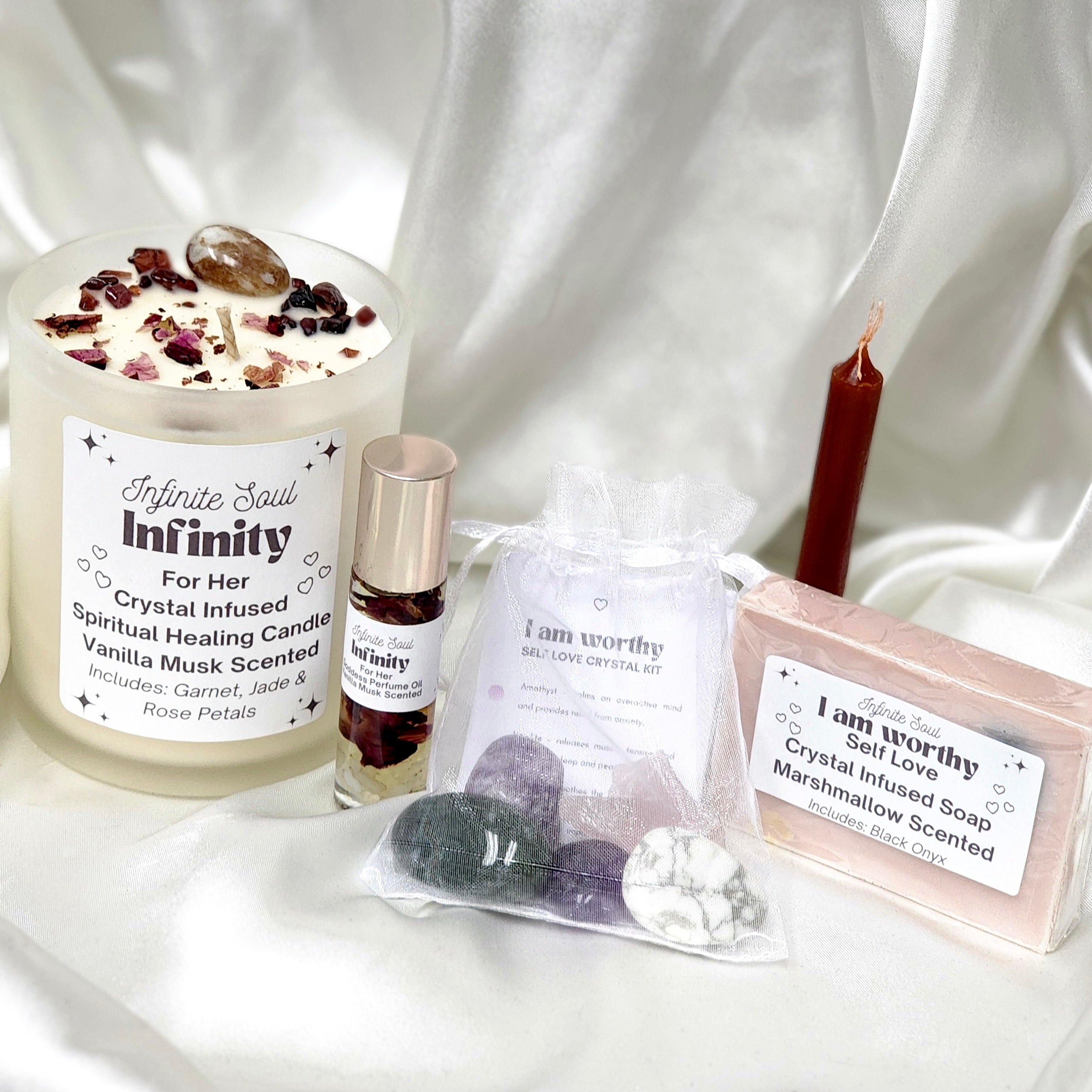 Infinity: For Her Bundle featuring a crystal infused candle, soap, manifestation candle, healing kit, and goddess perfume oil, all designed for spiritual healing.