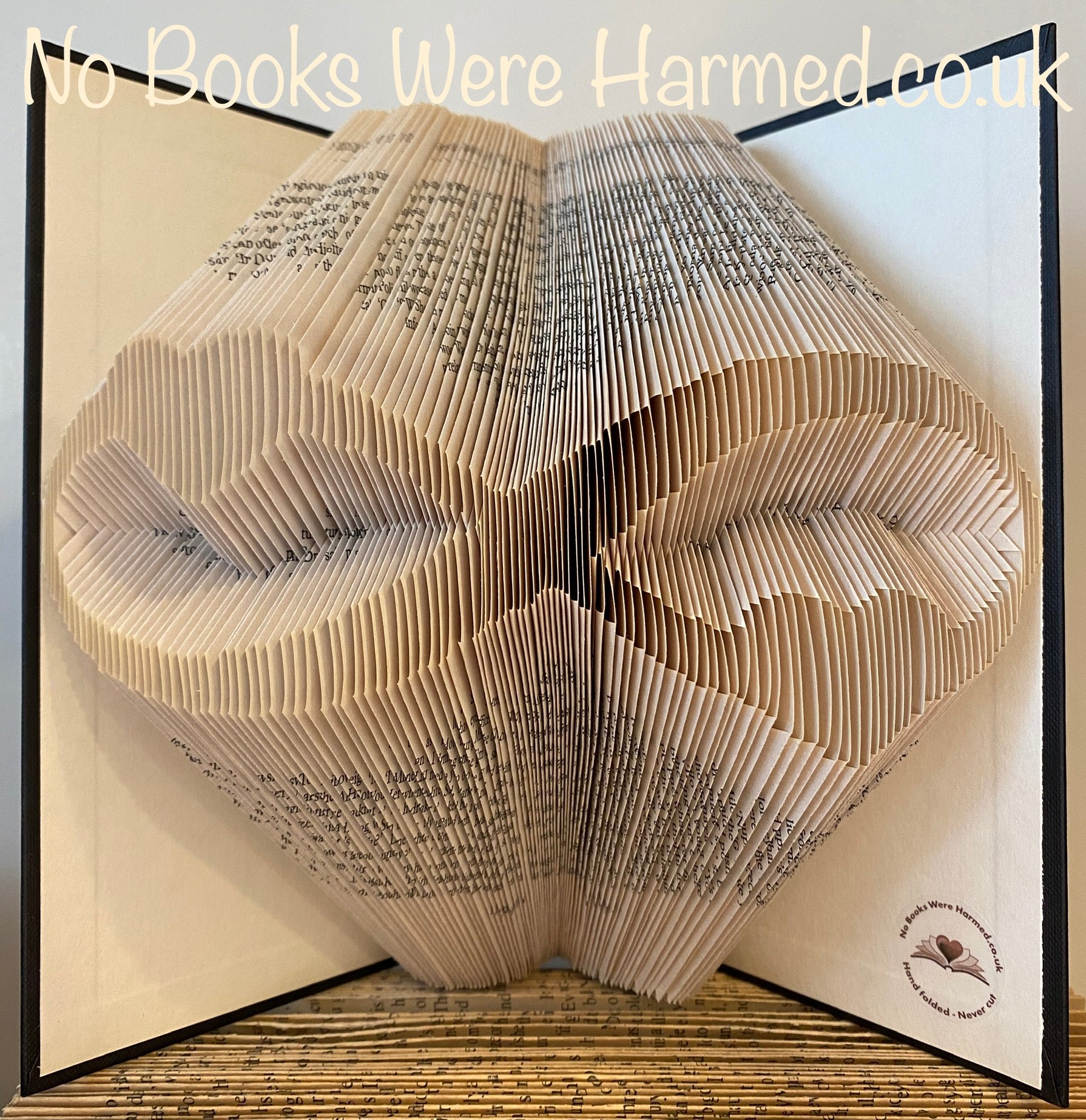 A beautifully crafted Infinity Hearts art piece made from hand-folded pages of vintage books, showcasing intricate designs and unique colors.