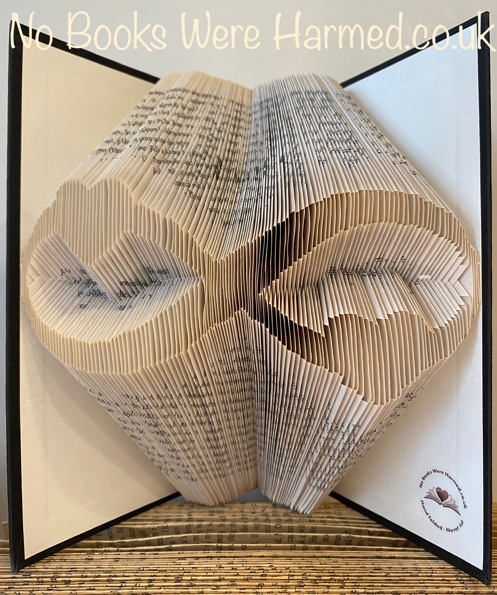 A beautifully crafted Infinity Hearts art piece made from hand-folded pages of vintage books, showcasing intricate designs and unique colors.