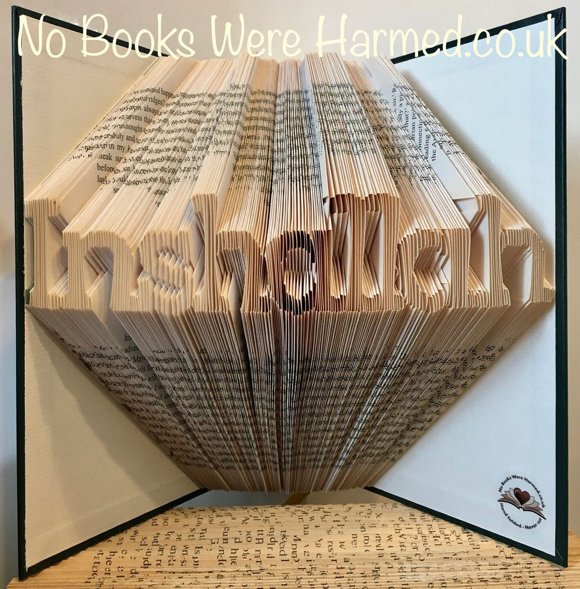 Handcrafted book art titled 'Inshallah', featuring intricately folded pages from vintage books, showcasing unique patterns and textures.