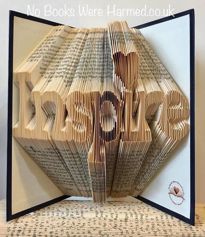 Hand-folded book art titled 'Inspire', showcasing intricate designs made from vintage books.