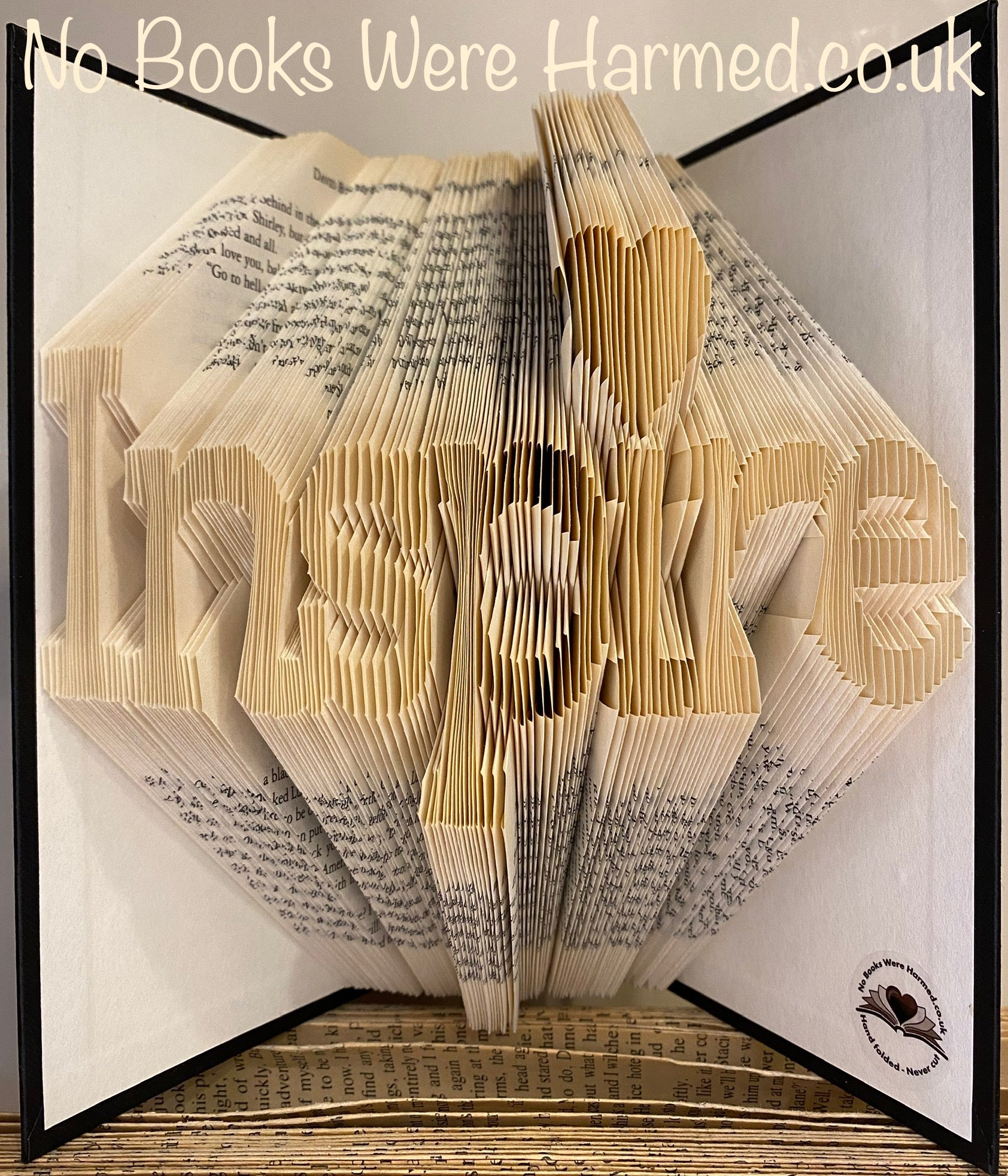 Hand-folded book art titled 'Inspire', showcasing intricate designs made from vintage books.