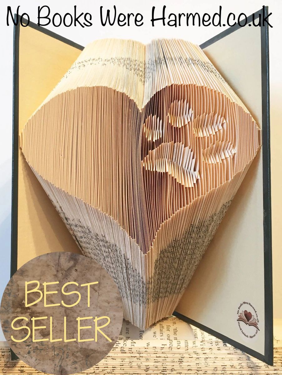 Handcrafted art piece featuring an inverted paw within a heart, made from vintage book pages, showcasing intricate folds and unique design.