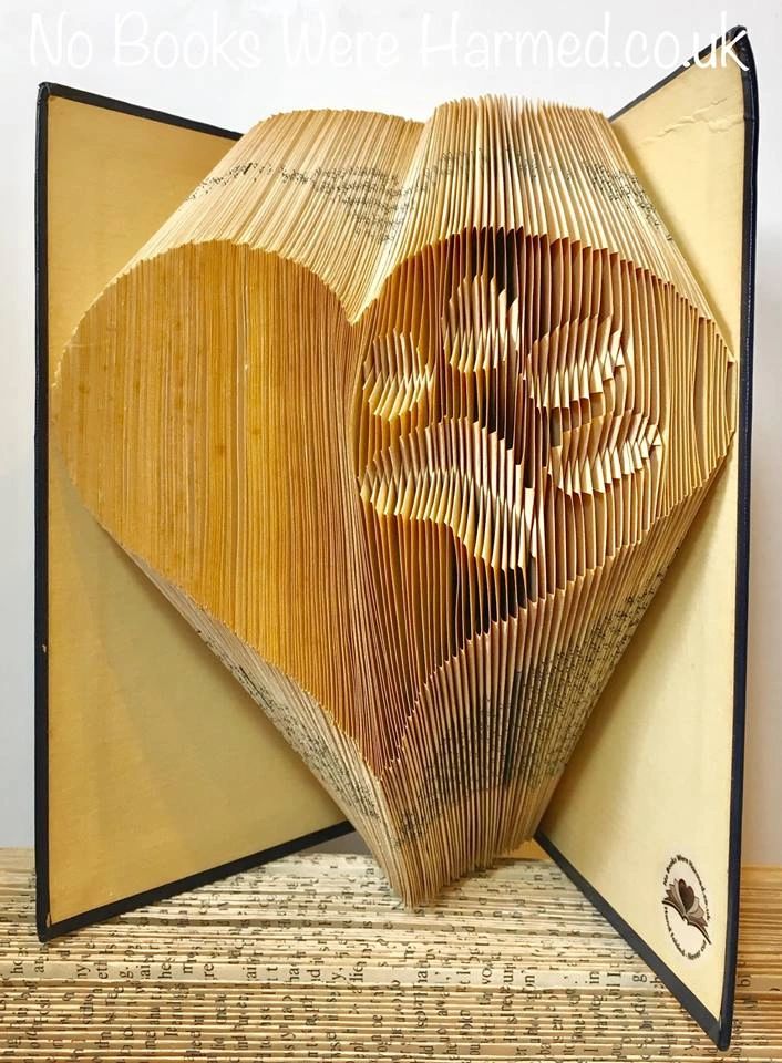 Handcrafted art piece featuring an inverted paw within a heart, made from vintage book pages, showcasing intricate folds and unique design.