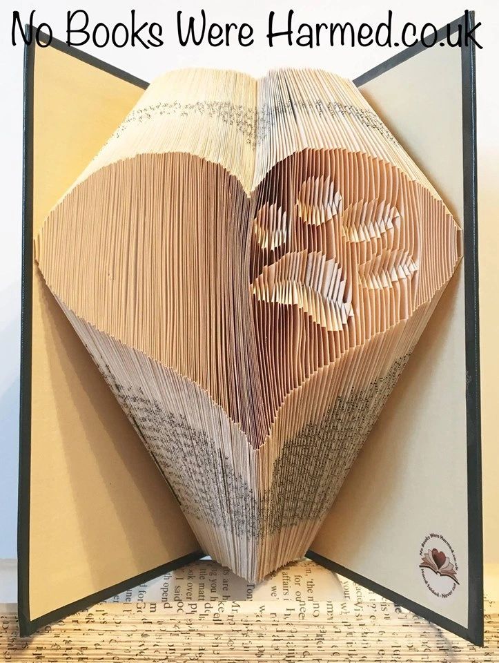 Handcrafted art piece featuring an inverted paw within a heart, made from vintage book pages, showcasing intricate folds and unique design.