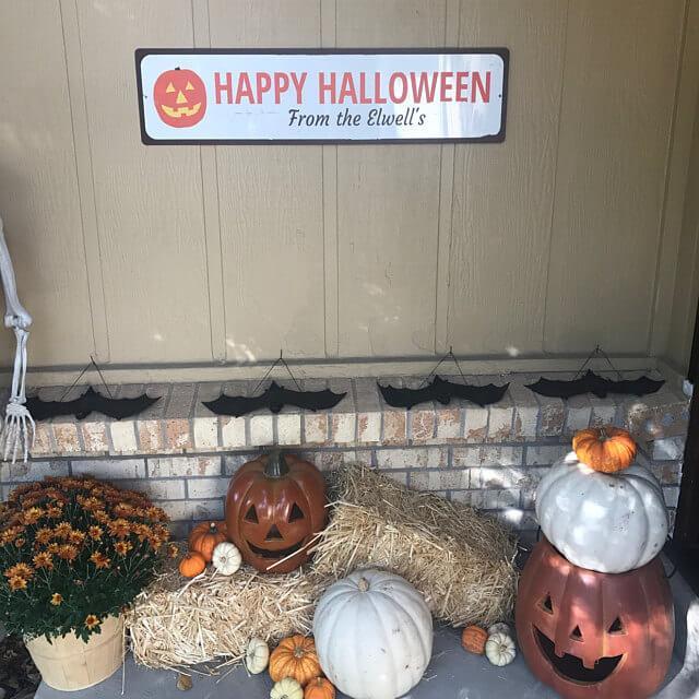 A decorative Jack-O-Lantern sign made of aluminum, featuring a spooky design perfect for Halloween decor.