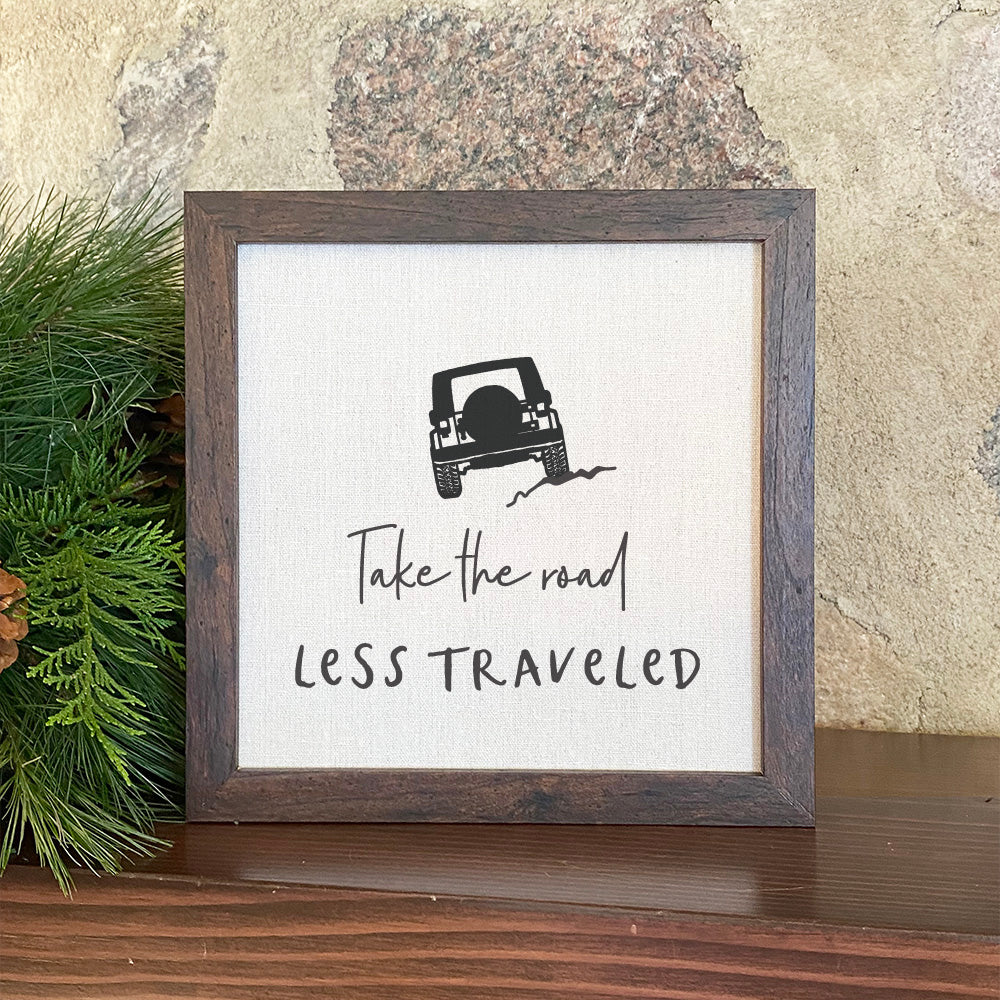 Jeep Road Less Traveled framed sign with a rustic wood frame and linen-look background, showcasing eco-friendly printing.