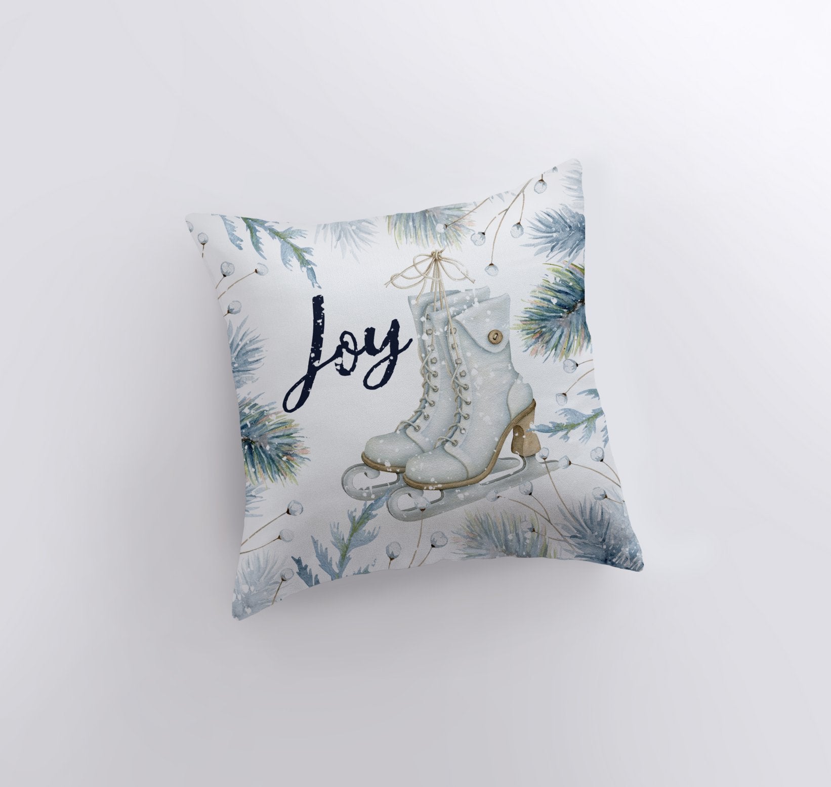 Joy Ice Skating Throw Pillow featuring white ice skates and cursive 'Joy' text with wintergreen branches, perfect for winter decor.