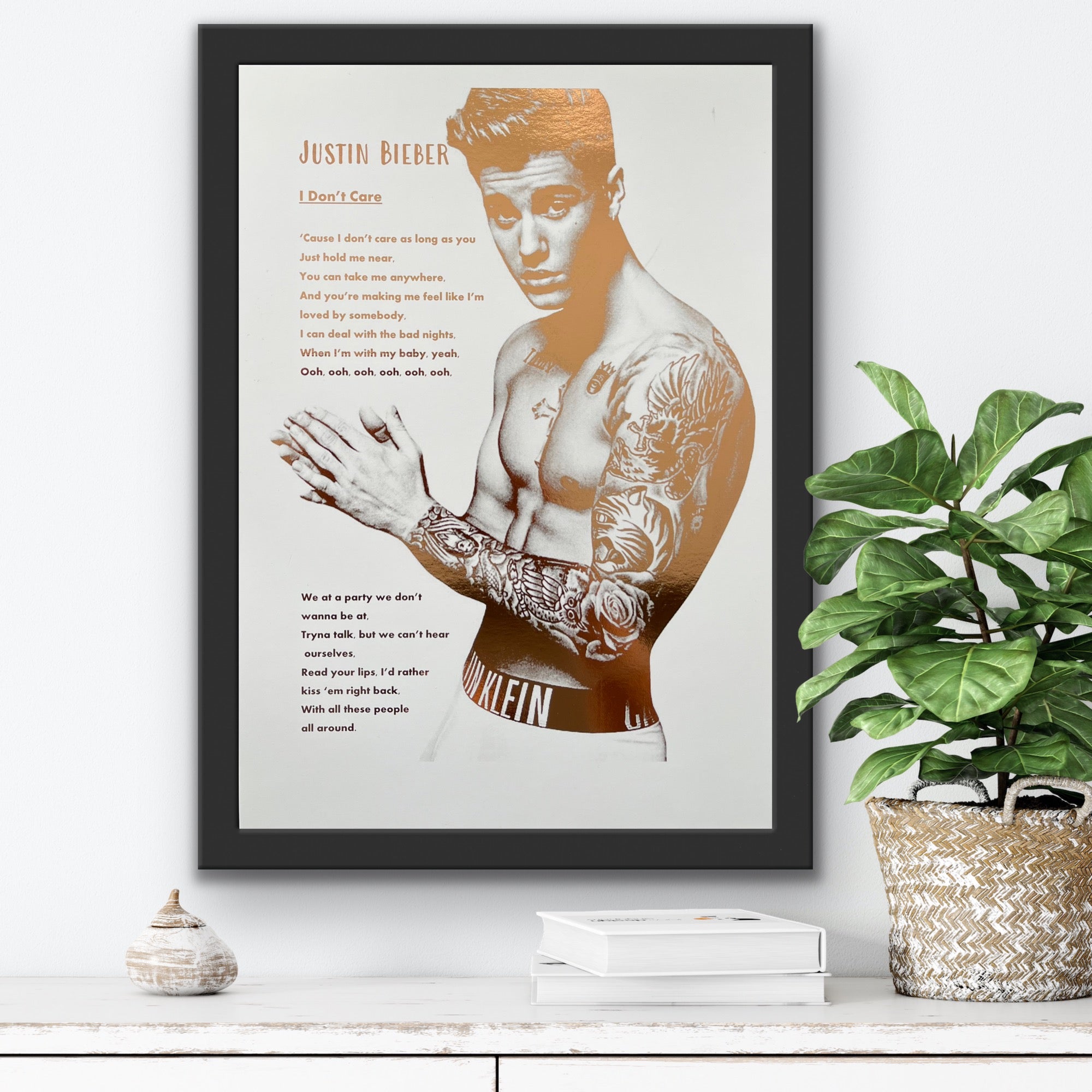 A stunning foil print of Justin Bieber featuring a rose gold portrait and song lyrics on a white background.