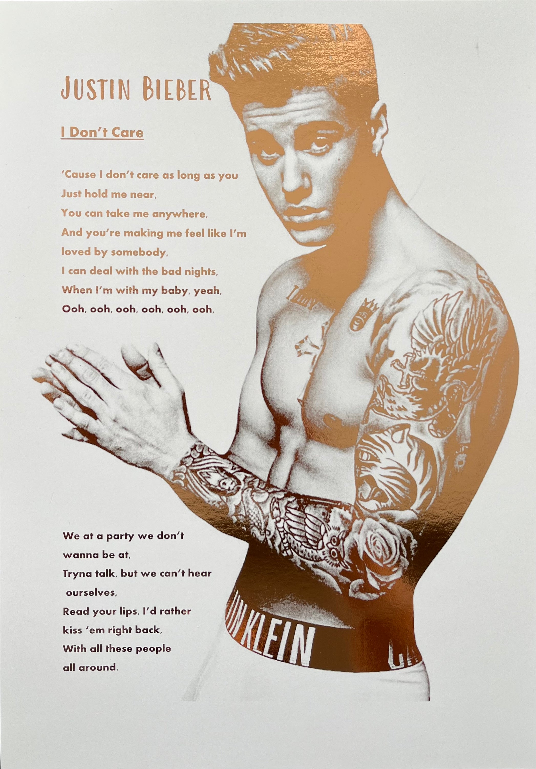 A stunning foil print of Justin Bieber featuring a rose gold portrait and song lyrics on a white background.