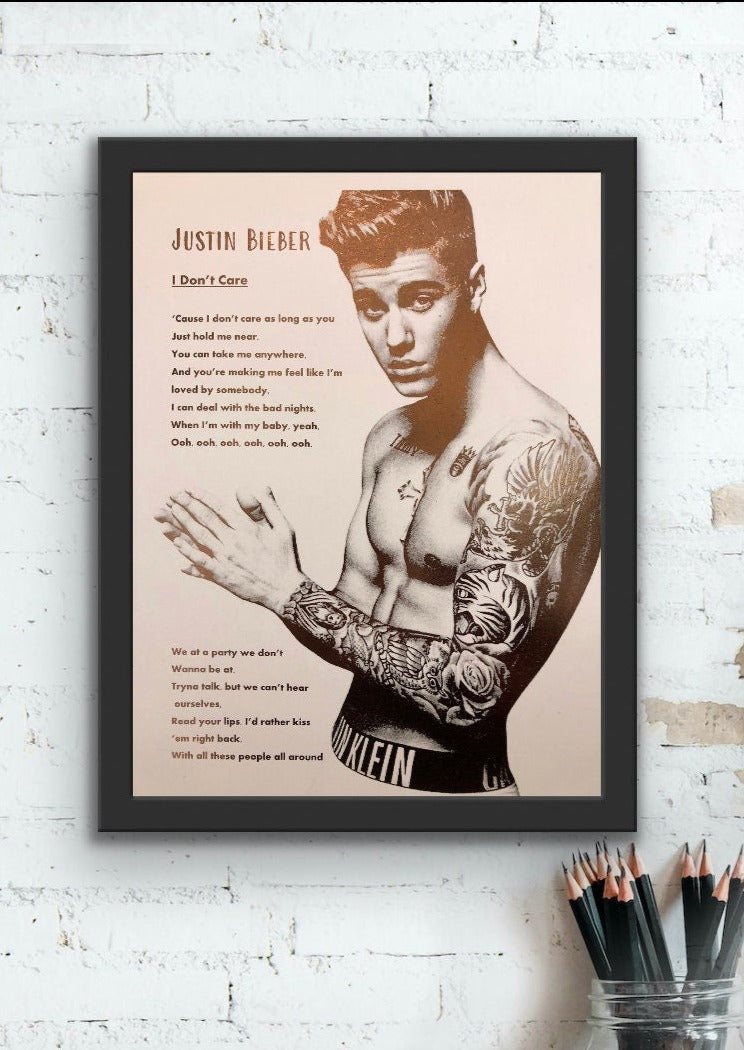 A stunning foil print of Justin Bieber featuring a rose gold portrait and song lyrics on a white background.