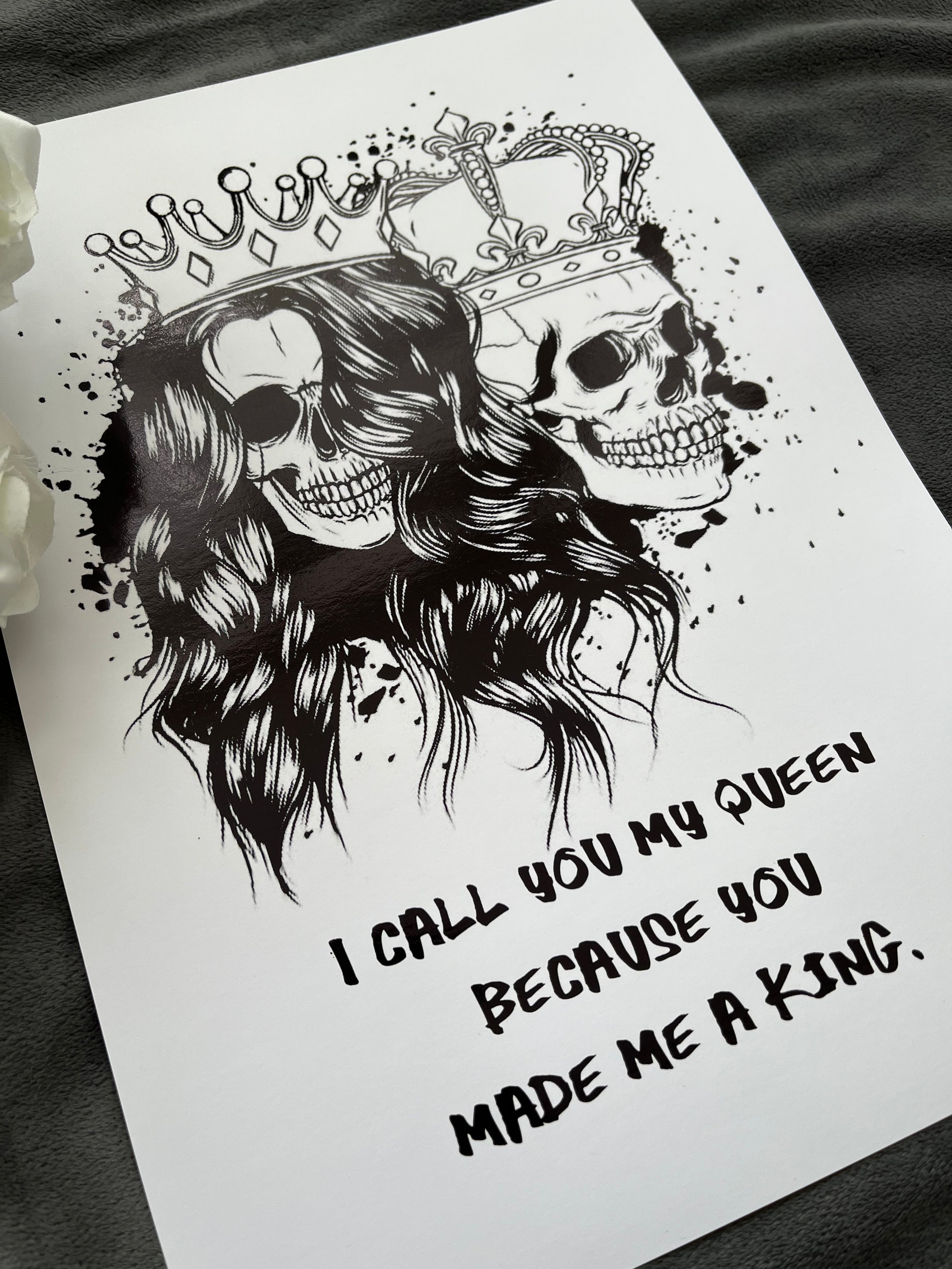 King & Queen Skull Foil Print featuring male and female skulls with crowns, showcasing intricate black foil details.