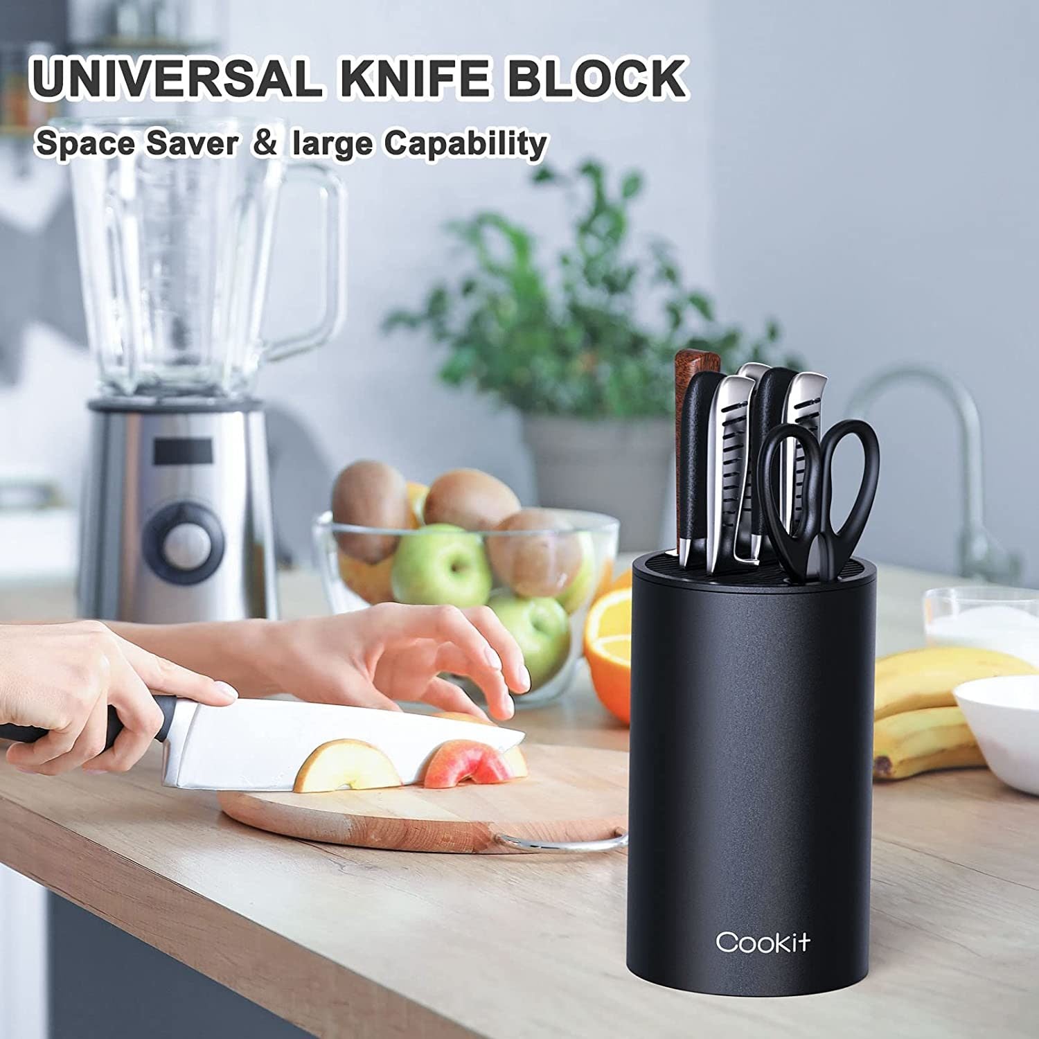 Person cutting fruit beside knife block