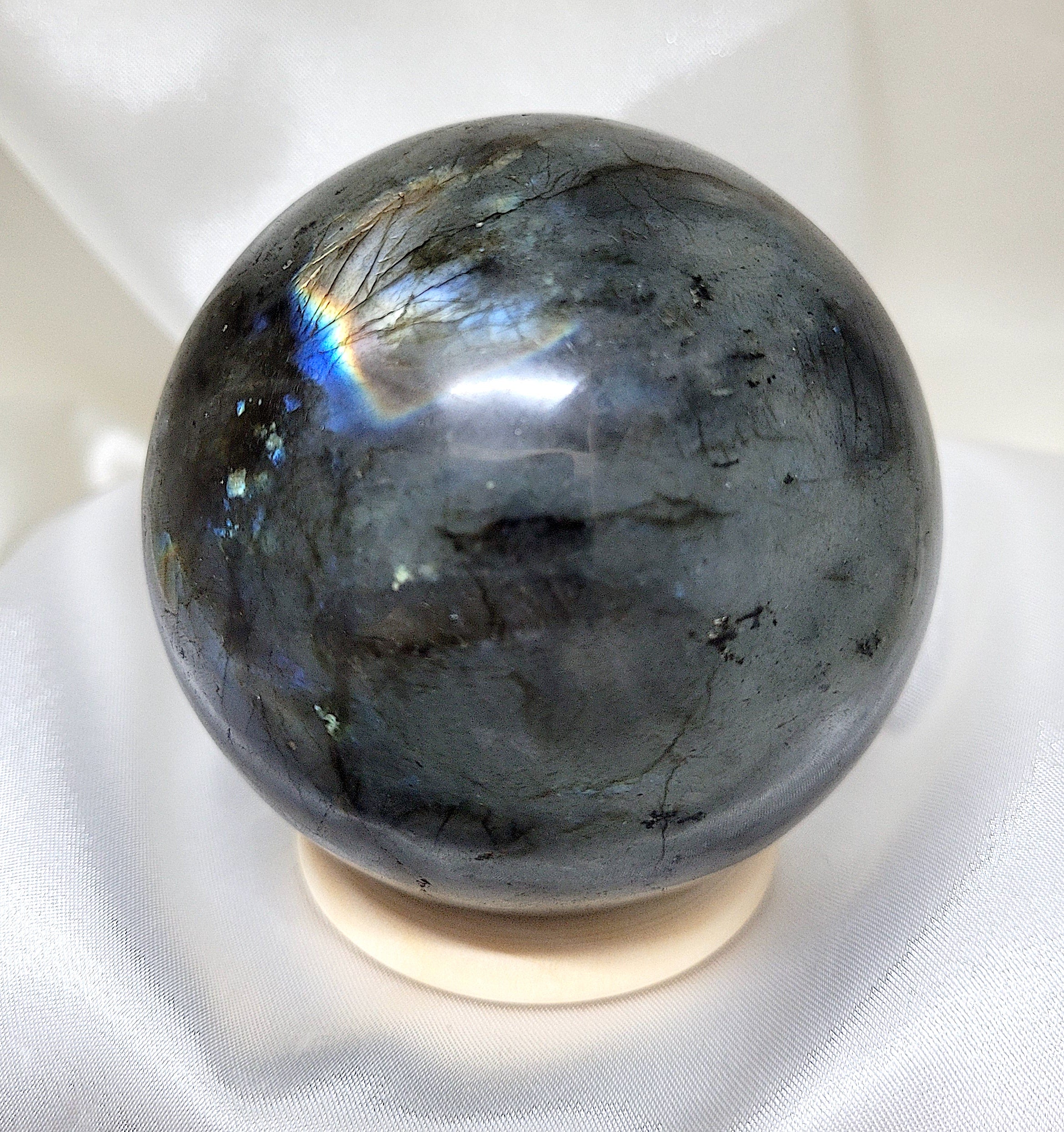 A beautifully polished labradorite sphere showcasing its iridescent colors and mystical patterns, perfect for spiritual practices and home decor.