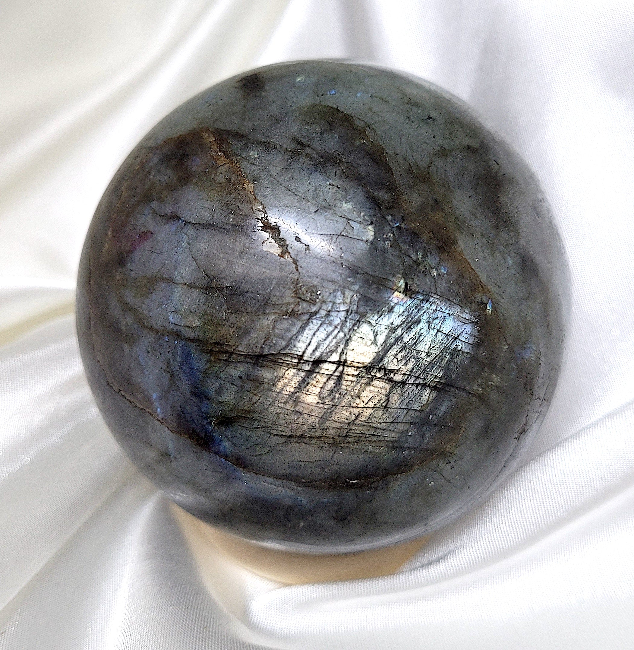 A beautifully polished labradorite sphere showcasing its iridescent colors and mystical patterns, perfect for spiritual practices and home decor.