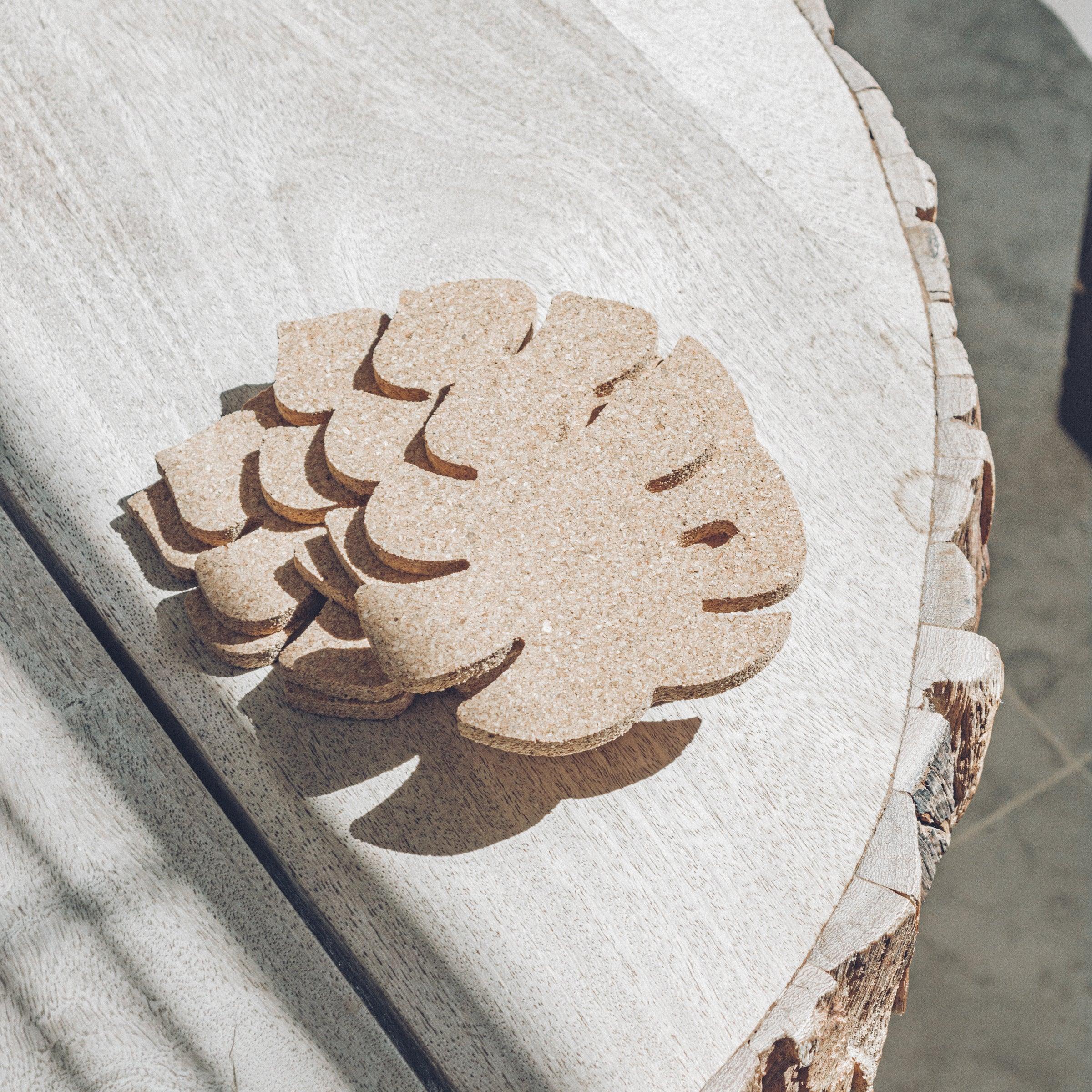 Set of six Monstera leaf shaped cork coasters, eco-friendly and stylish for home decor.