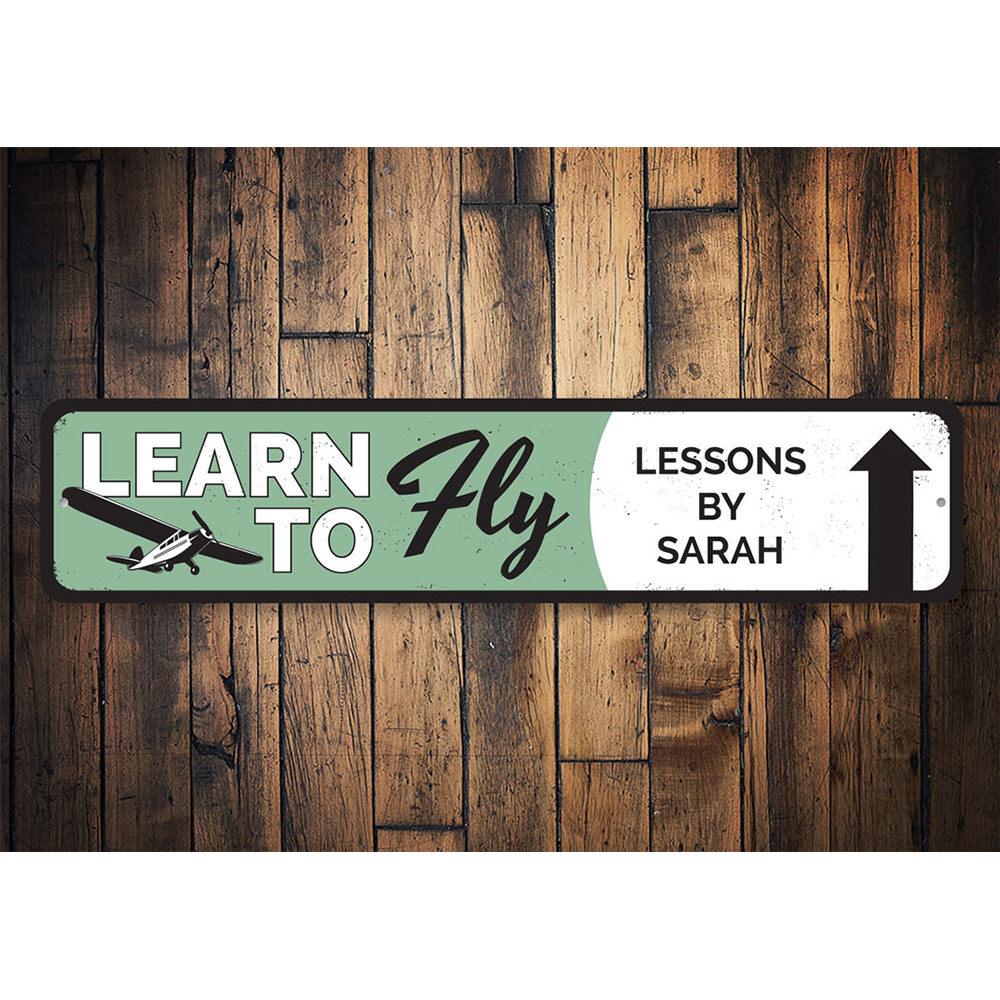 Learn To Fly Arrow Sign made from quality aluminum, featuring customizable text and pre-drilled holes for easy mounting.