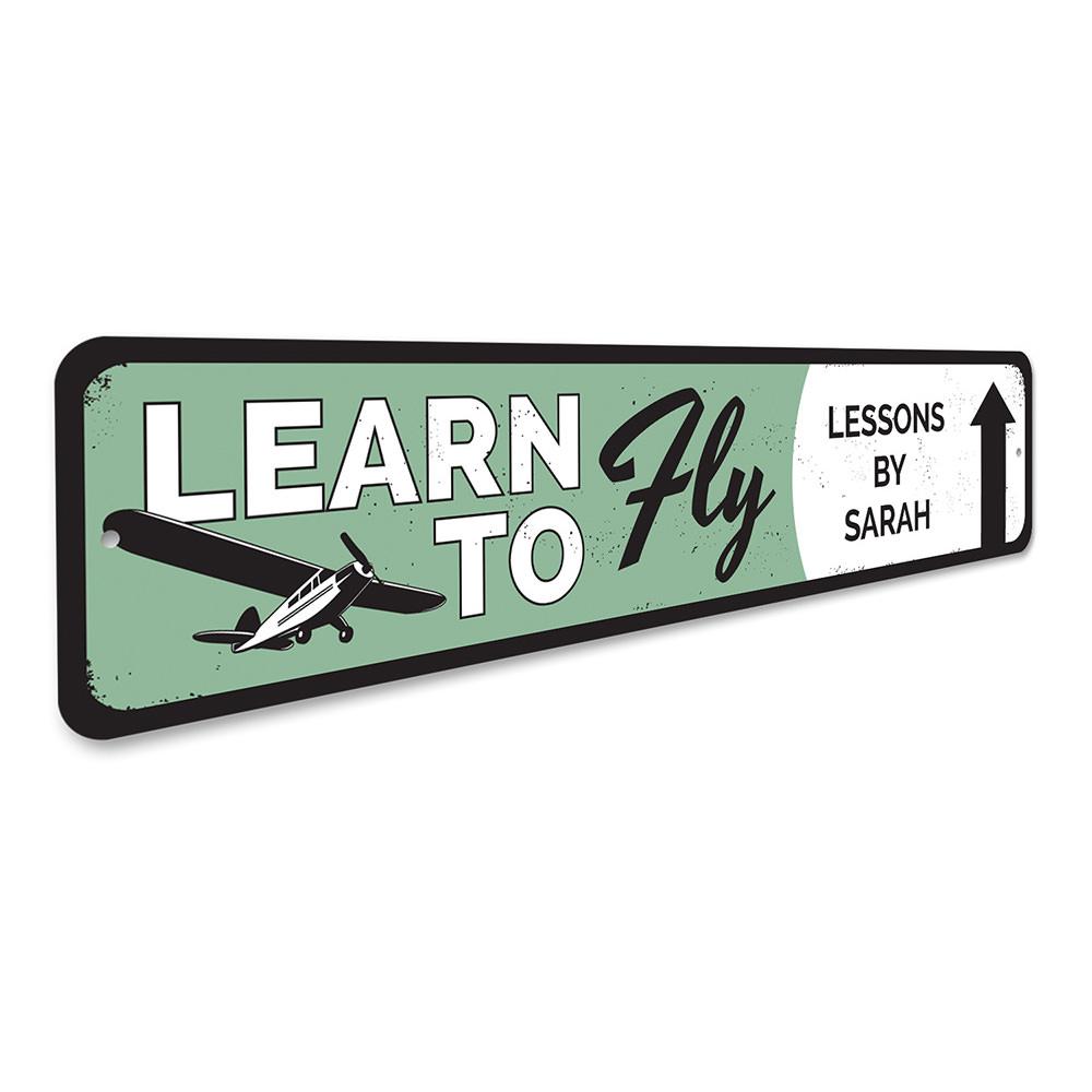 Learn To Fly Arrow Sign made from quality aluminum, featuring customizable text and pre-drilled holes for easy mounting.