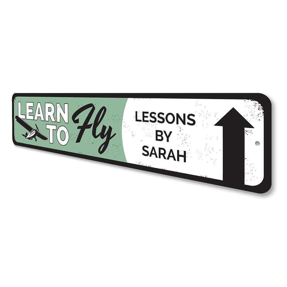 Learn To Fly Arrow Sign made from quality aluminum, featuring customizable text and pre-drilled holes for easy mounting.