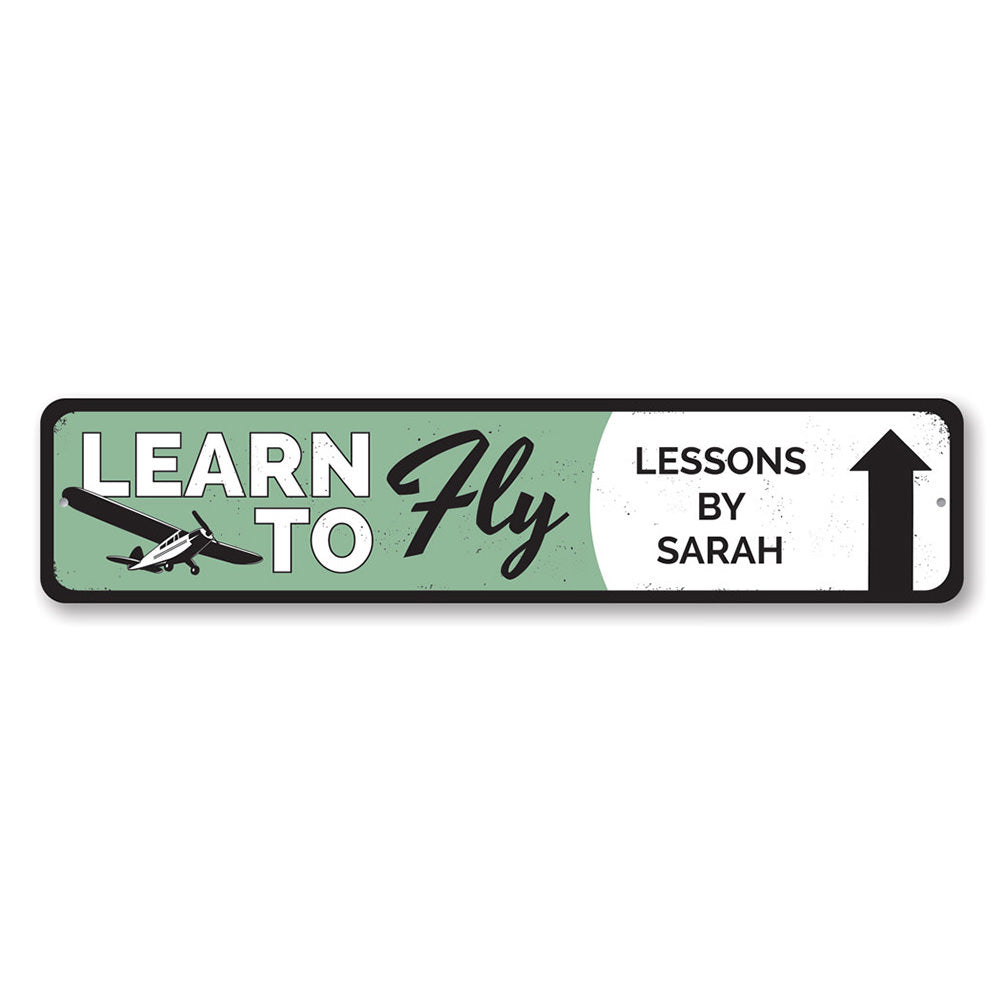 Learn To Fly Arrow Sign made from quality aluminum, featuring customizable text and pre-drilled holes for easy mounting.