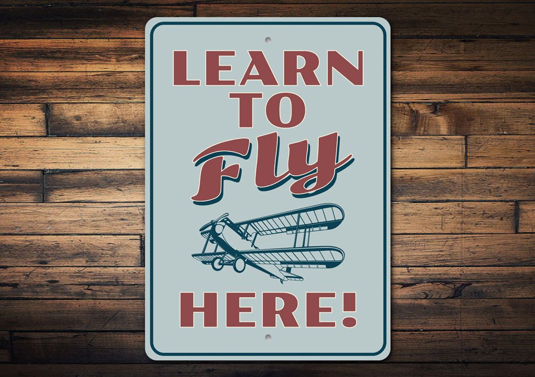 A decorative Learn to Fly Aviation Sign made of high-quality aluminum, featuring aviation-themed graphics and customizable text options.