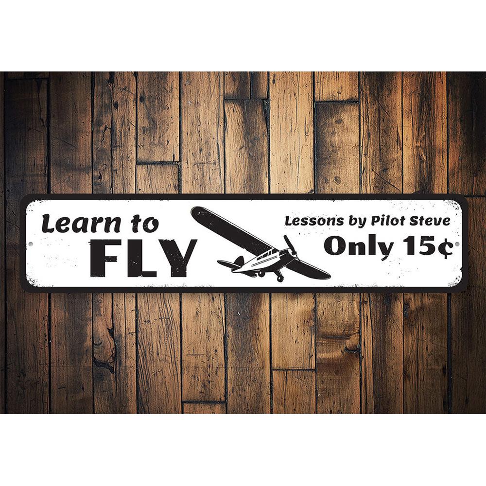 A decorative Learn To Fly Sign made of high-quality aluminum, featuring customizable text, ideal for home decor.