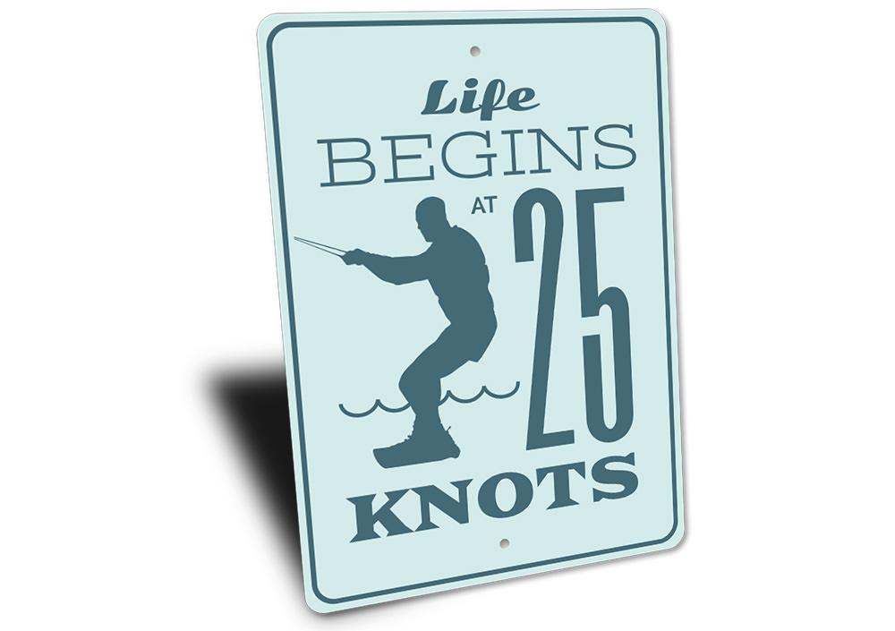 Life Begins at 25 Knots decorative sign made of aluminum, featuring a coastal theme, perfect for beach houses and outdoor decor.