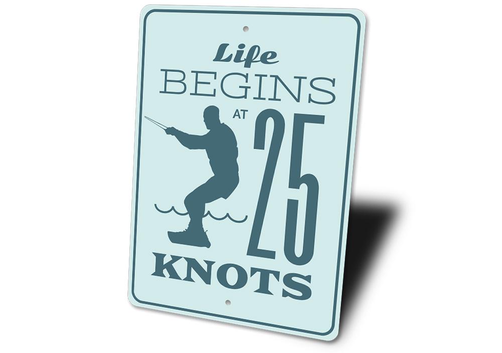 Life Begins at 25 Knots decorative sign made of aluminum, featuring a coastal theme, perfect for beach houses and outdoor decor.