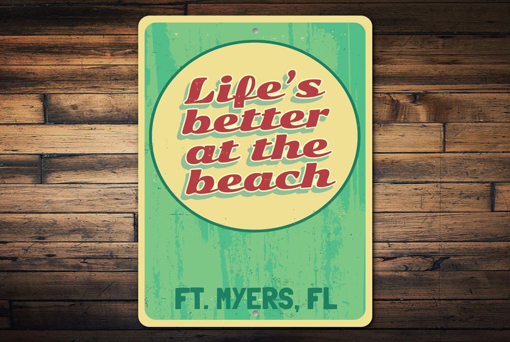 A decorative metal sign reading 'Life is Better at the Beach', featuring a coastal design, perfect for beach houses and seaside decor.