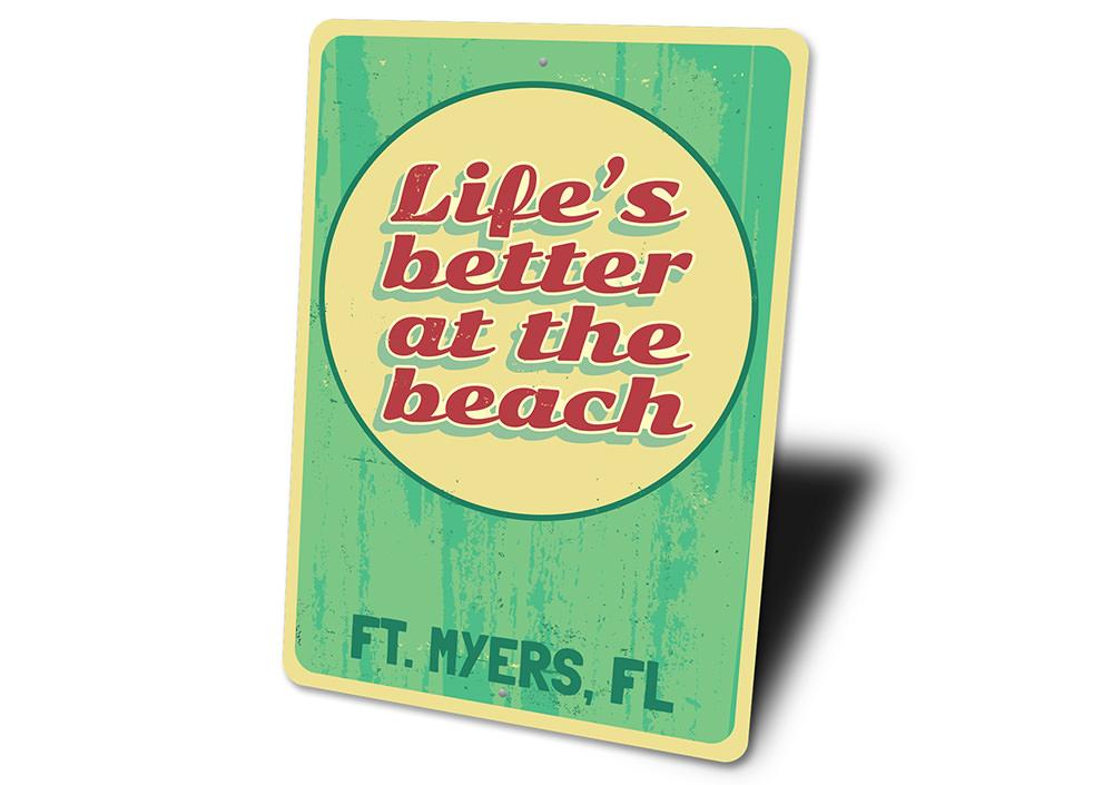 A decorative metal sign reading 'Life is Better at the Beach', featuring a coastal design, perfect for beach houses and seaside decor.