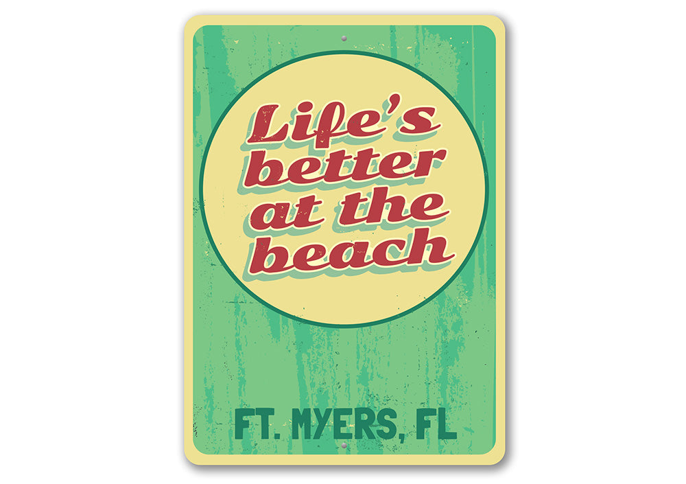 A decorative metal sign reading 'Life is Better at the Beach', featuring a coastal design, perfect for beach houses and seaside decor.