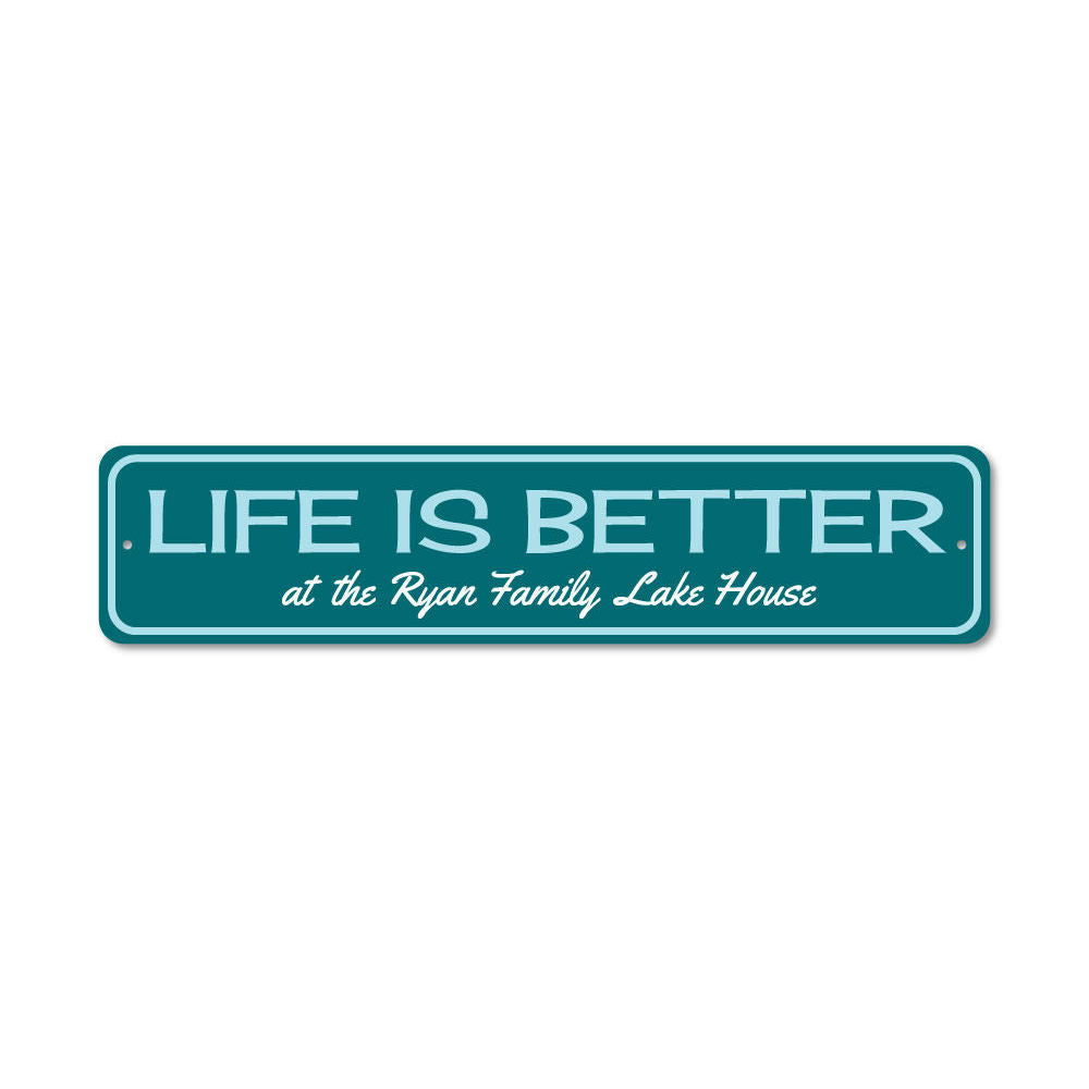 A decorative metal sign reading 'Life Is Better at the Lake', showcasing a beautiful lakeside theme, perfect for lakehouse decor.