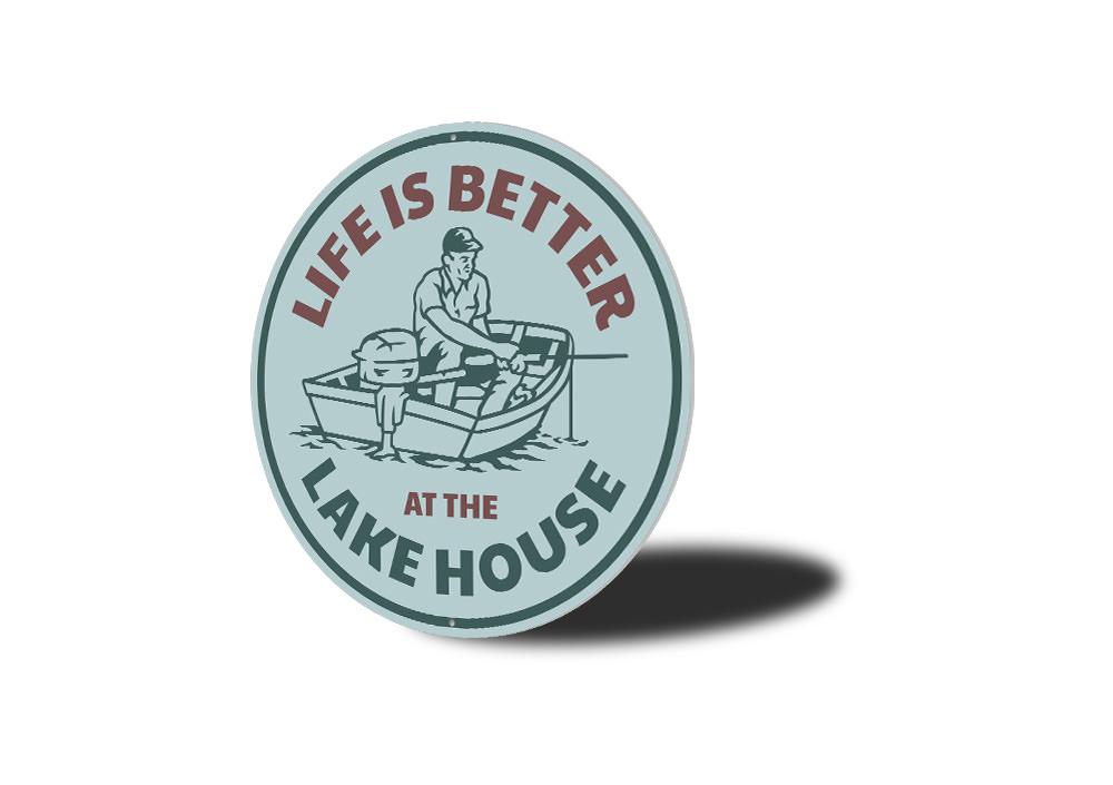 A decorative metal sign reading 'Life is Better at the Lake House', showcasing a beautiful lakeside theme, perfect for home decor.