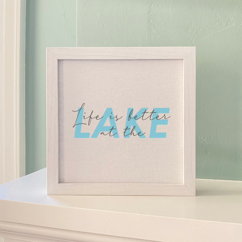 Framed sign reading 'Life is Better at the Lake' with a stylized wood frame, available in walnut or white-washed finish.