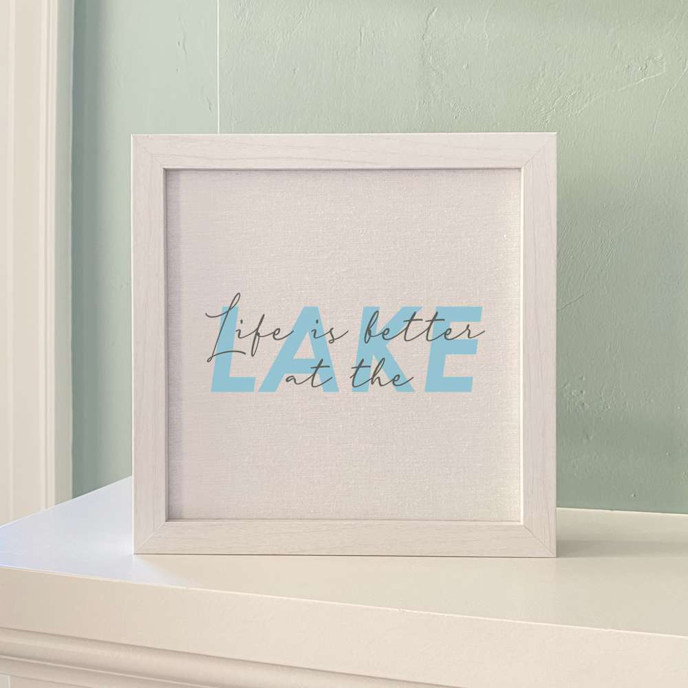 Framed sign reading 'Life is Better at the Lake' with a stylized wood frame, available in walnut or white-washed finish.