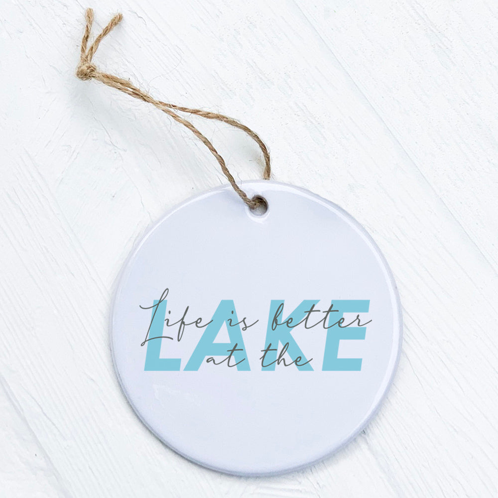 A beautifully crafted porcelain ornament featuring the phrase 'Life is Better at the Lake', showcasing a glossy finish and vibrant design.