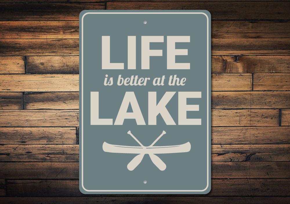 A decorative metal sign reading 'Life is Better at the Lake', showcasing a beautiful lakeside theme, perfect for lakehouses.