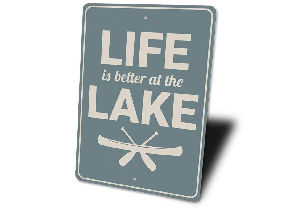 A decorative metal sign reading 'Life is Better at the Lake', showcasing a beautiful lakeside theme, perfect for lakehouses.