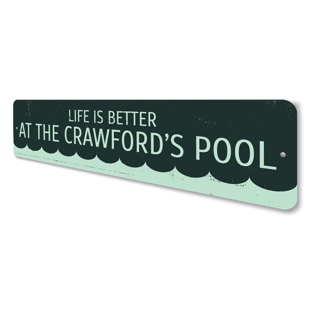 A decorative metal sign that reads 'Life is Better at the Pool', showcasing vibrant colors and a stylish design, perfect for poolside decor.