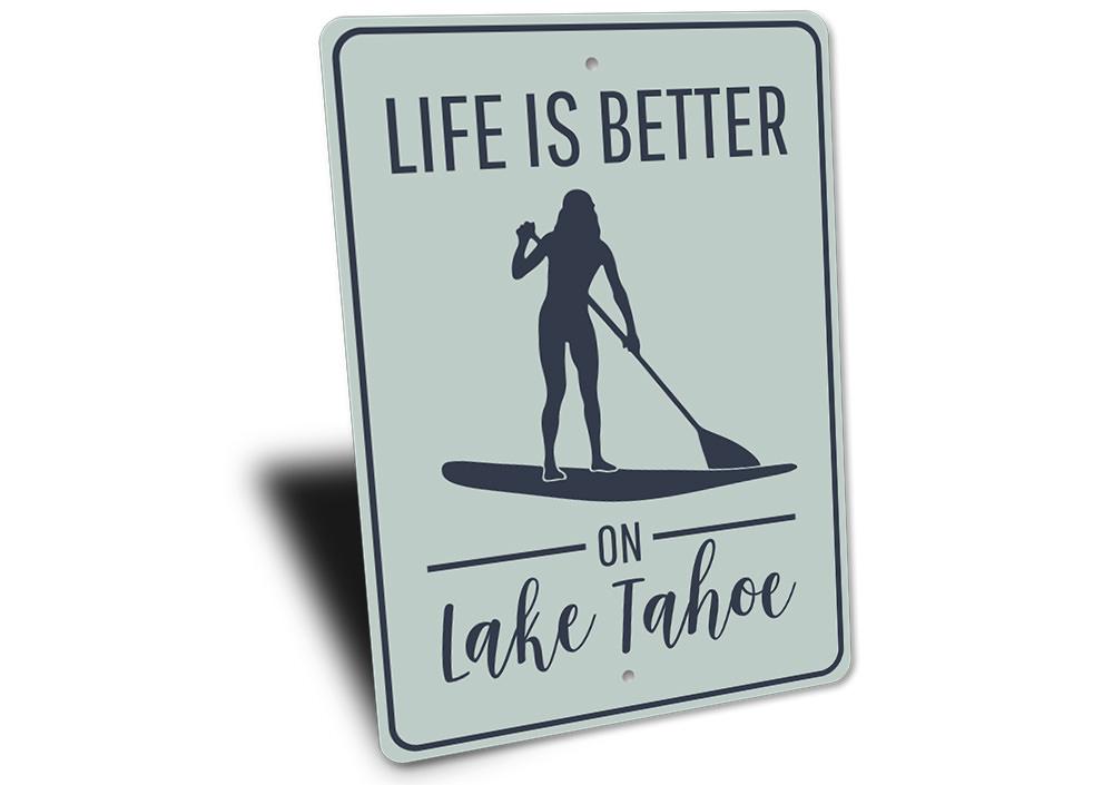 A decorative metal sign that reads 'Life is Better on Lake Tahoe', showcasing a beautiful lake theme, perfect for lakehouse decor.