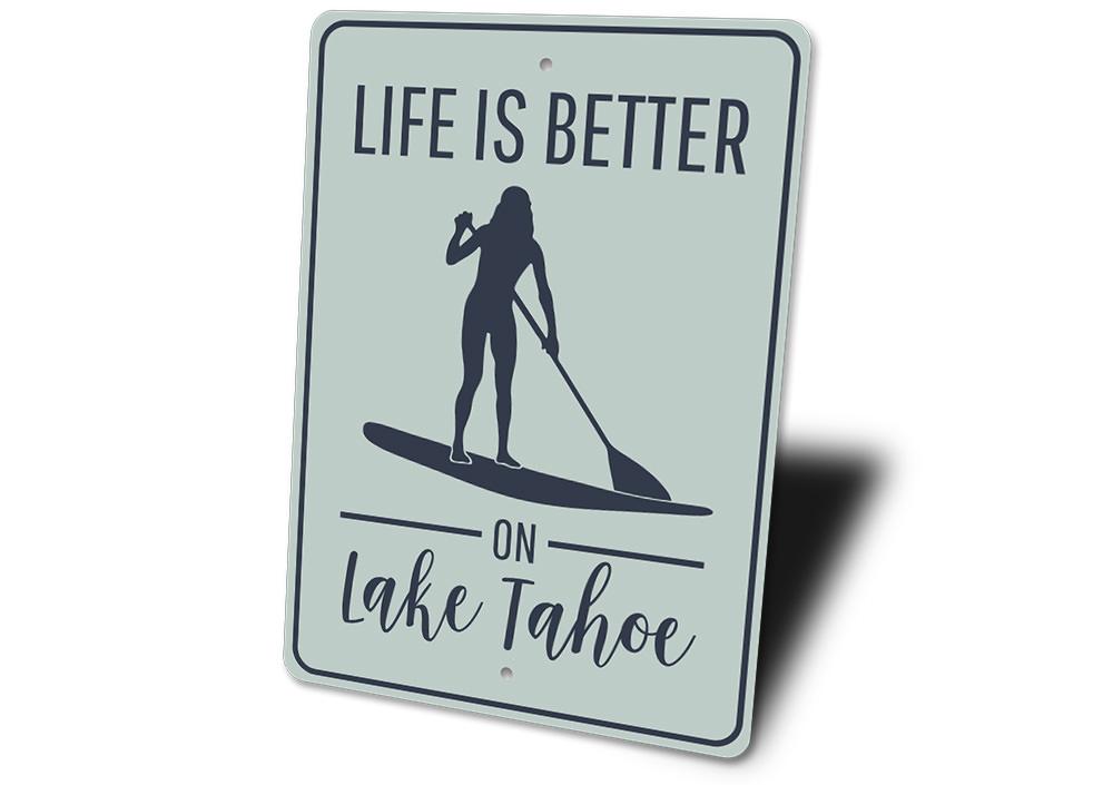 A decorative metal sign that reads 'Life is Better on Lake Tahoe', showcasing a beautiful lake theme, perfect for lakehouse decor.