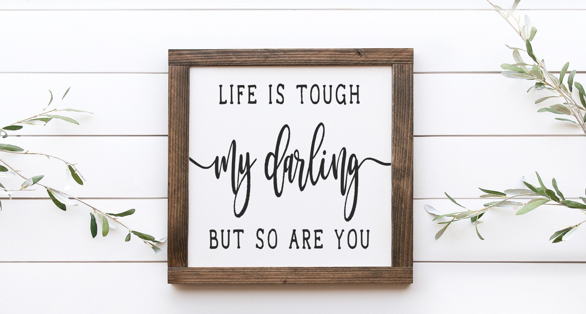 Inspirational wood sign reading 'Life Is Tough My Darling But So Are You', featuring a matte white background and unique wood grain.