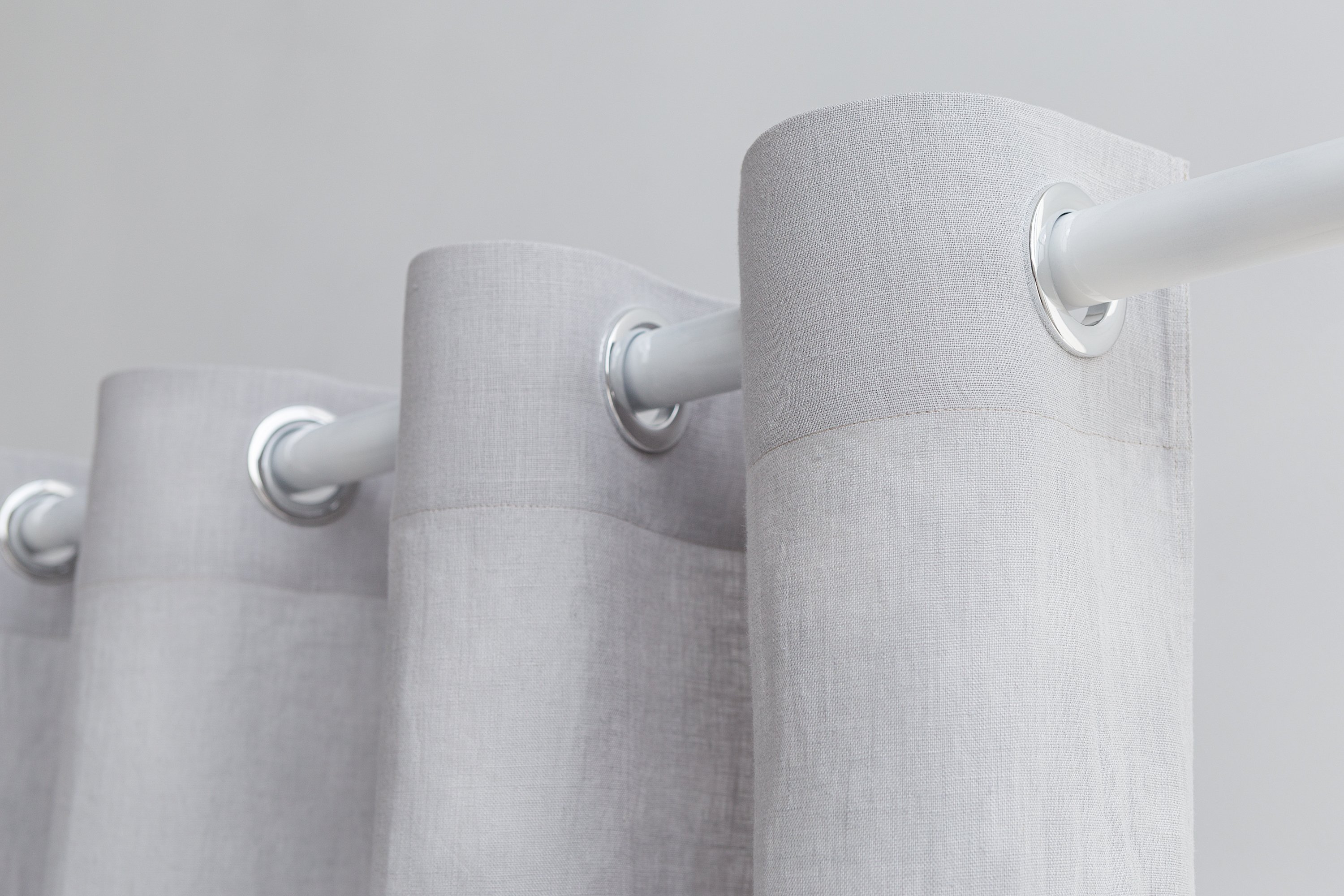 Light grey linen curtain with grommets, showcasing elegant draping and natural texture.