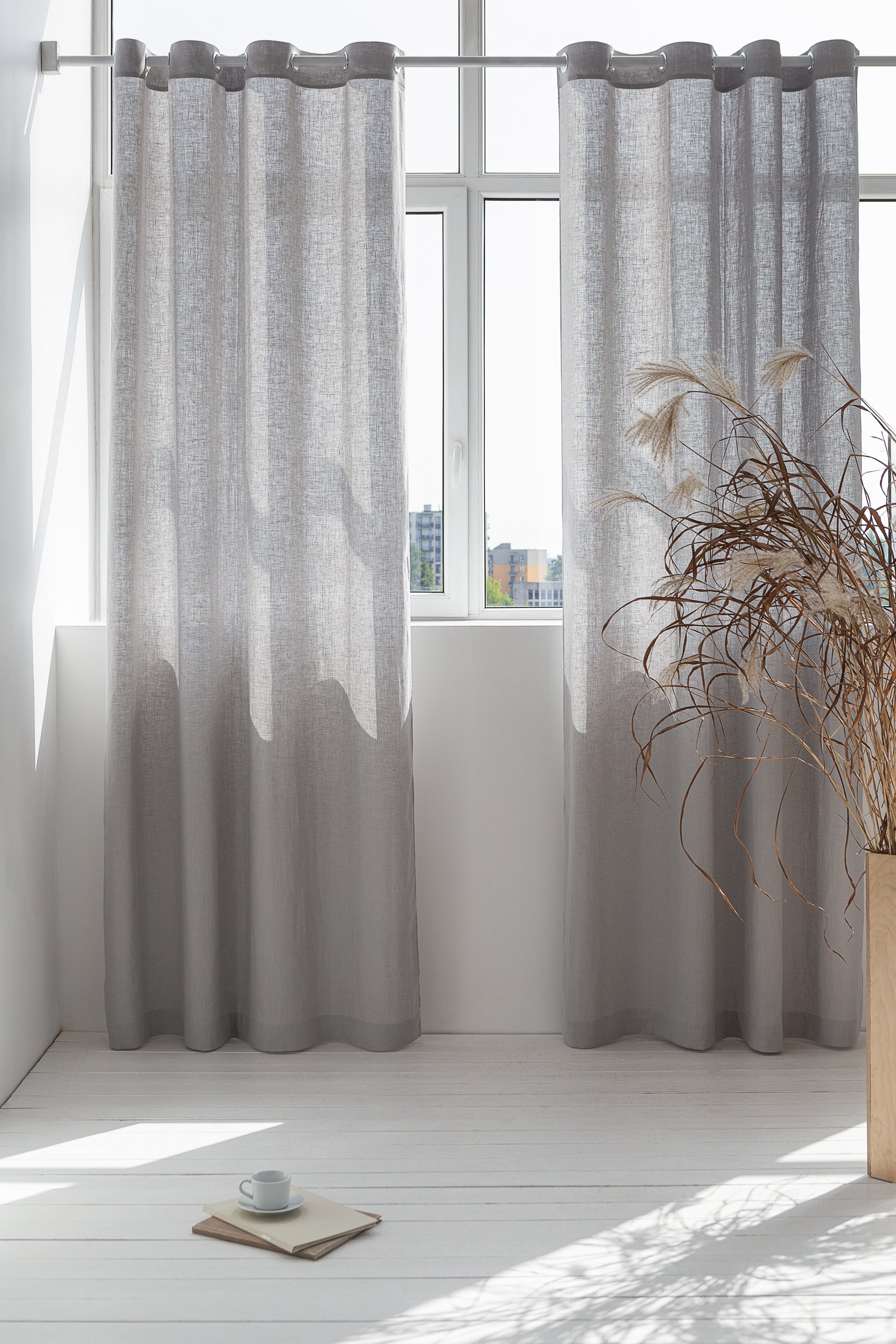 Light grey linen curtain with grommets, showcasing elegant draping and natural texture.