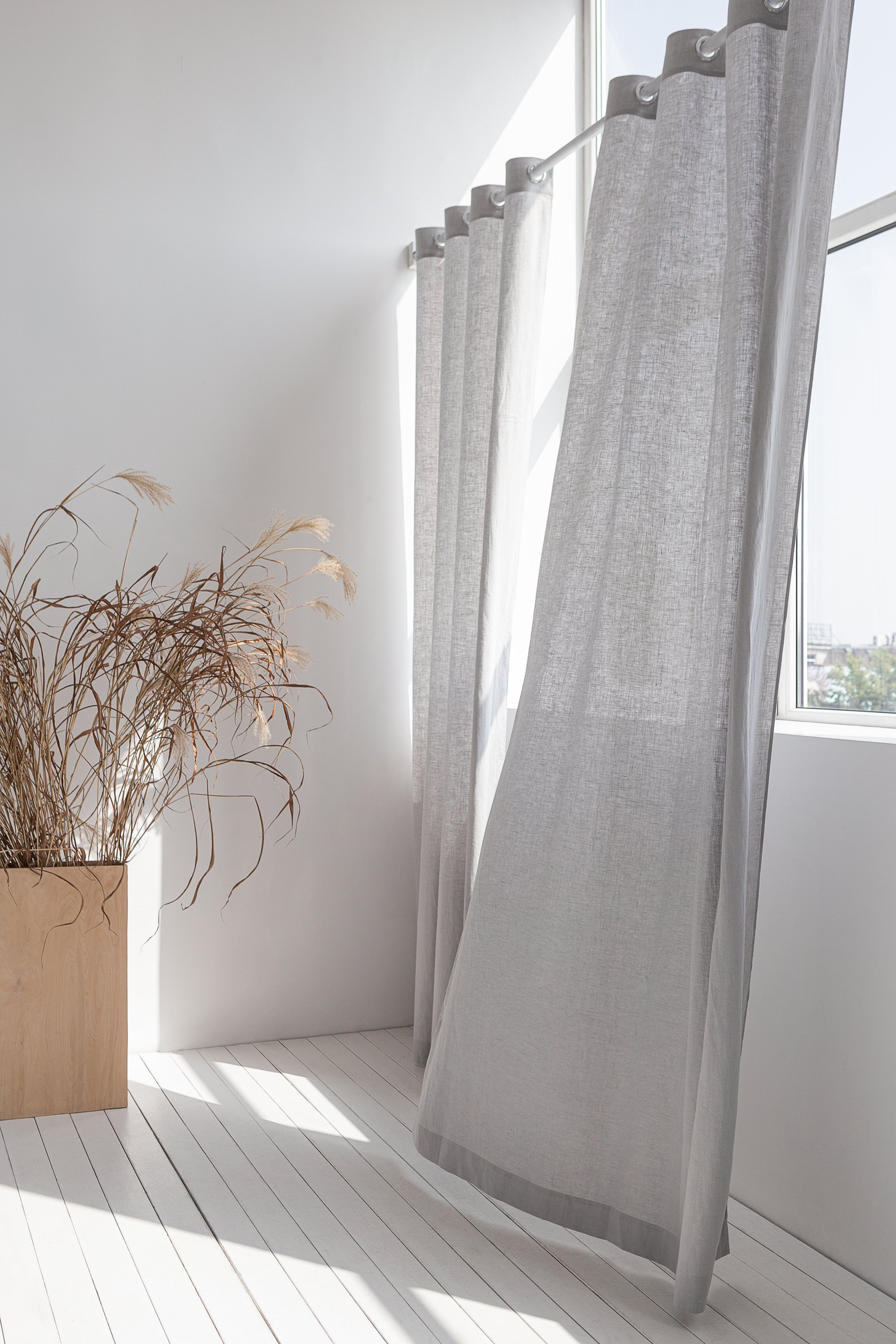 Light grey linen curtain with grommets, showcasing elegant draping and natural texture.